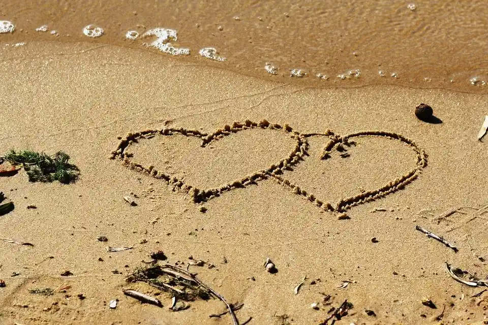 "Serce narysowane na piasku na plaży"